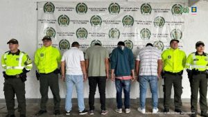 En la fotografía se aprecian de pie y de ellos de espalda a la cámara a los cuatro integrantes de ‘Los del Alto’. A sus extremos hay uniformados de la Policía Nacional. En la parte posterior hay un pendón institucional de la Policía.