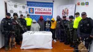 En la fotografía aparecen los 5 capturados junto a cuatro servidores del CTI, dos agentes de la Policía Nacional y dos soldados del Ejército Nacional. En la parte posterior se observa una mesa con bolsas plásticas con estupefacientes, tres teléfonos celulares y dinero en efectivo.