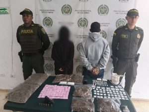 En la fotografía aparece de espaldas a la cámara, con los brazos atrás y esposado Luis Alfonso García Navia. Viste con buso de color gris claro y jean azul. A sus extremos hay uniformados de la Policía Nacional. Delante de ellos hay una superficie de color verde oscuro y sobre ella hay bolsas plásticas transparentes que contienen material vegetal; bolsas pequeñas transparentes con contenido rosado y blanco. Un arma de fuego, munición y una picadora. En la parte posterior hay un pendón institucional de la Policía.