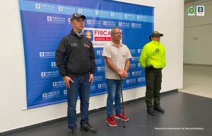 Se observa al capturado en el centro, a un lado un funcionario del CTI y al otro uno de Policía Nacional. Al fondo un penmdón de la Fiscalía General de la Nación