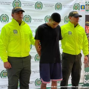 En la fotografía se aprecia de pie, con los brazos atrás y la cabeza agachada a Luis Felipe Ramírez Ocampo, alias Pipe Pollo. Viste camiseta negra de manga corta y bermuda negra con ribetes blancos y rojos en el dobladillo de la misma. A sus extremos hay uniformados de la Policía Nacional. Detrás de ellos hay un pendón institucional de la Policía.