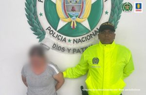  En la foto está la procesada con el rostro distorsionado y un servidor de la Policía Nacional