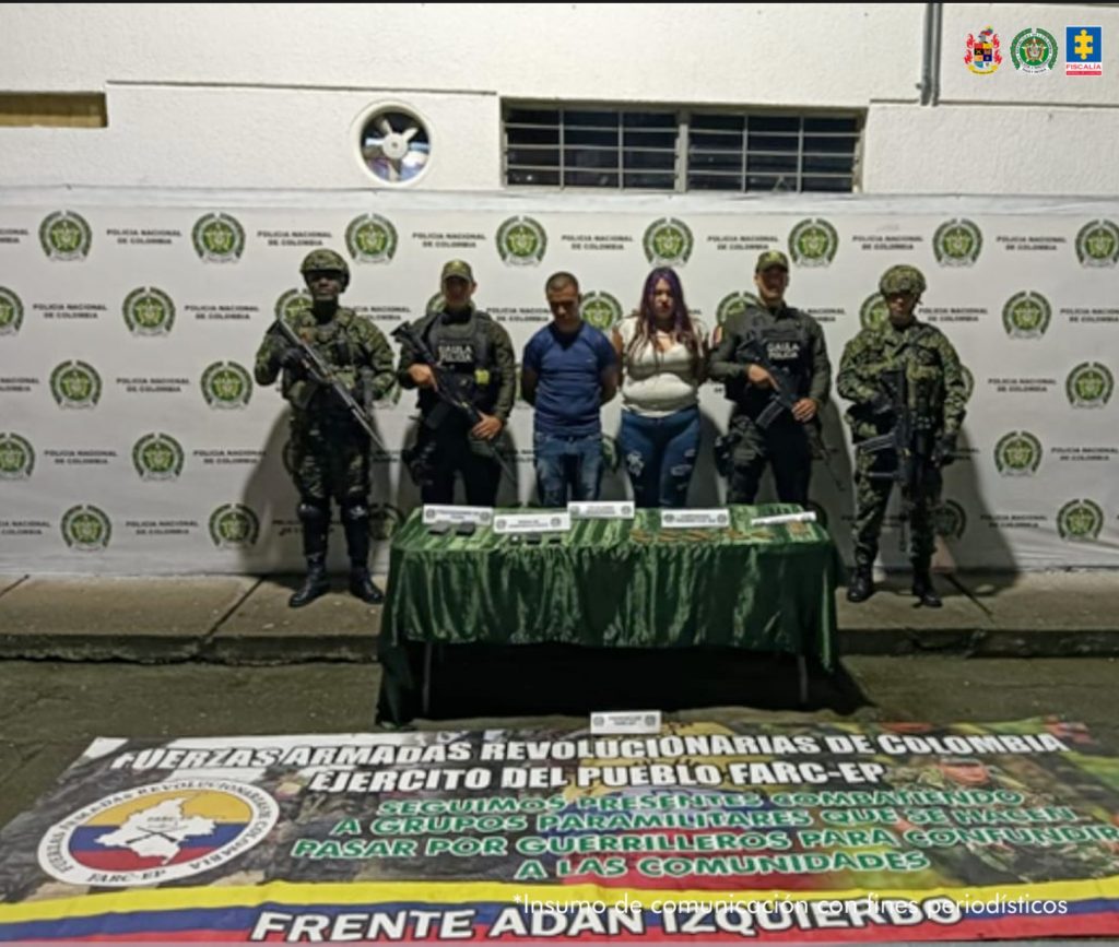 En la fotografía se aprecian de pie y con los brazos atrás a Maira Alejandra Lizarazo Rincón y Juan Camilo Hernández Moreno. La mujer usa cabello largo y viste con blusa blanca y jean azul desgastado. El hombre viste camisa azul de manga corta y jean azul desgastado. En los extremos hay uniformados del Ejército y de la Policía Nacional. Delante de ellos hay una mesa con mantel verde y sobre ella hay munición y otros elementos incautados. En el suelo hay una pancarta alusiva a las Farc - EP frente Adán Izquierdo. Detrás de ellos hay un pendón institucional de la Policía.
