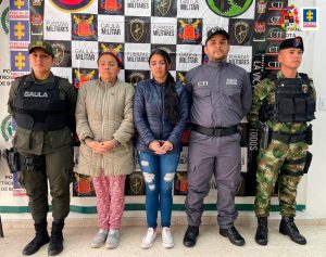 En la fotografía aparece un capturado, junto a personal de Fiscalía General de la Nación y Policía Nacional. En la parte posterior de la imagen se ven banners de Policía Nacional y la Fiscalía General de la Nación.     