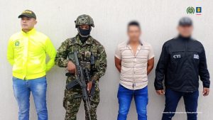 El capturado se encuentra de frente y custodiado por un servidor del Cuerpo Técnico de Investigación CTI, un uniformado de la Policía y el Ejército Nacional.