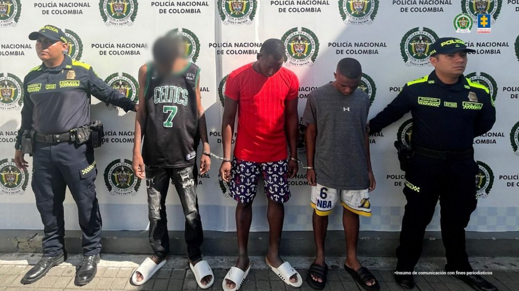 En la fotografía se aprecian de pie, en hilera, esposados entre sí y con la cabeza agachada a Marlon Stiven Solís Padilla y Javier Danilo Estupiñán Arboleda. Uno, viste con camiseta de color rojo y manga corta; bermudas con estampado de unas anclas de color blanco y rojo y pantuflas de color blanco. El otro viste camiseta de color gris, de manga corta; bermudas de color blanco con bordes amarillos, el número 6 y las letras ‘NBA’; así como pantuflas de color negro. A sus extremos hay uniformados de la Policía Nacional y detrás de ellos hay un pendón institucional de la Policía.