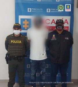 En la fotografía se aprecia de pie, con los brazos atrás y la cabeza agachada, a Luis Fernando Sierra Santander. Viste camiseta de manga corta blanca y jean azul, así como gorra y zapatillas de color negro con blanco. Al lado izquierdo de él hay un servidor del CTI de la Fiscalía y al lado derecho un uniformado de la Policía Nacional. Detrás de ellos hay un pendón institucional de la Fiscalía.