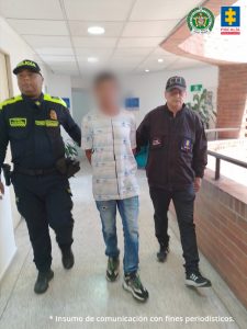 Fiscal Mancera, Fiscal Martha Mancera, Martha Mancera, Fiscalía General de la Nación En la fotografía se aprecia en un pasillo, acción de caminata y con los brazos atrás, a Mario Montoya Sánchez. Viste camisa de manga corta blanca estampada, jean azul desgastado y zapatillas negó con blanco. Al lado izquierdo de él hay un servidor del CTI de la Fiscalía y al lado derecho un uniformado de la Policía Nacional.