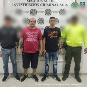 Se visualiza a los dos capturados junto a un investigador del CTI y uniformado de la Policía Nacional. Detrás de ellos el banner que identifica a la Sección de Investigación Criminal -Sijin de la Policía Nacional.