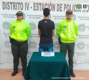 Fiscal Mancera, Fiscal Martha Mancera, Martha Mancera Está un hombre de pie, de espalda con los brazos hacía adelante, custodiado por dos policías. Delante de ellos hay un pendón de esa institución.