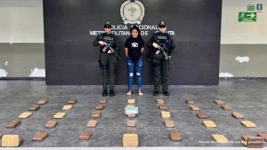 Se visualiza a la capturada junto a dos uniformados del Gaula de la Policía Nacional. Frente a ellos la sustancia incautada. Detrás de ellos el banner que identifica a la Policía Nacional.