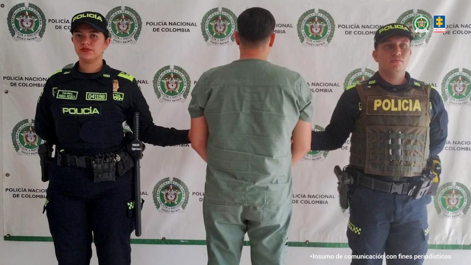El capturado se encuentra de espalda y custodiado por uniformados de laPolicía Nacional. 