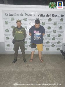 En la foto se aprecia al capturado junto a un uniformado de la Policía Nacional. En la parte posterior se observa el banner de la Estación de Policía de Villa del Rosario (Norte de Santander).