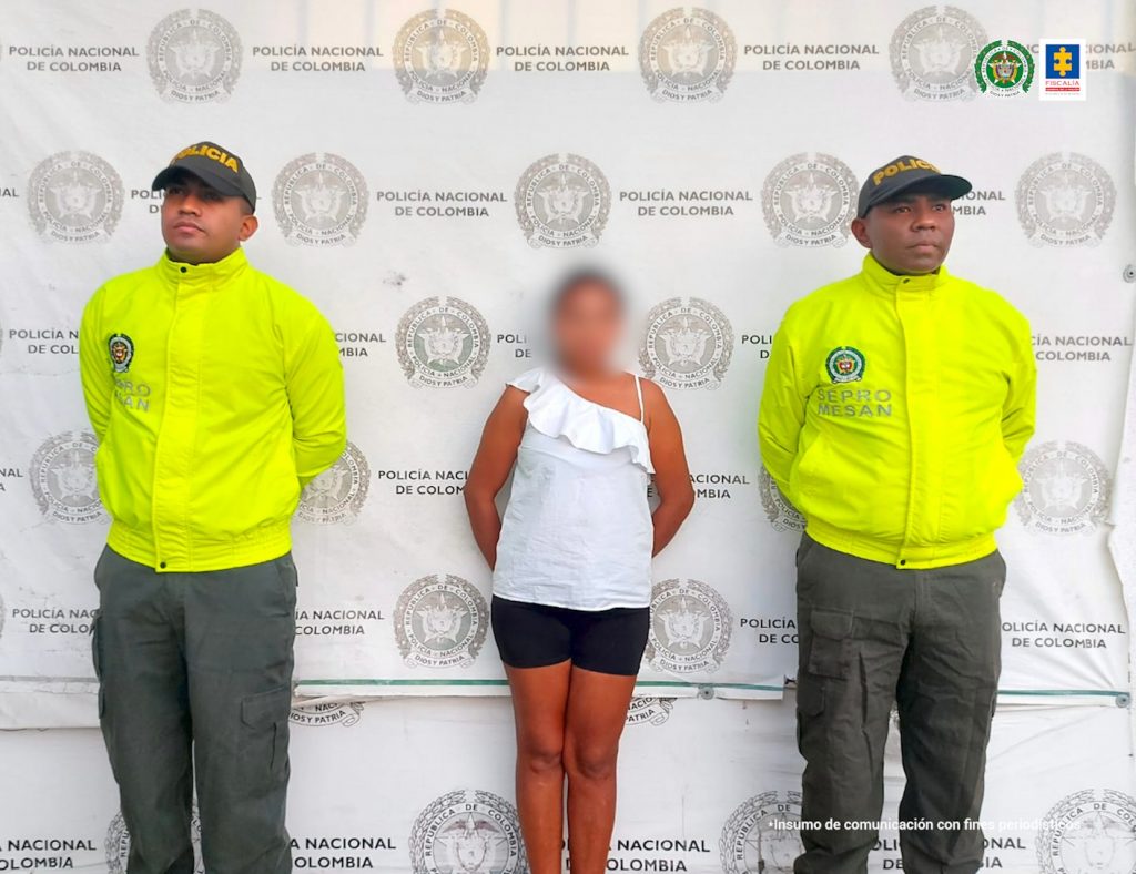 En la fotografía está la procesada con una blusa de color blanco. A su lado están dos uniformados de la Policía de Infancia y Adolescencia de Santa Marta.