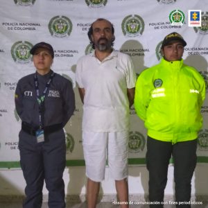 En  la fotografía se aprecia a Norberto De Jesús Montoya Sánchez, de pie y con los brazos atrás. Viste camisa y bermuda de color blanco y pantuflas. Usa barba y bigote, cejas pobladas y en la parte del cabello presenta entradas pronunciadas.