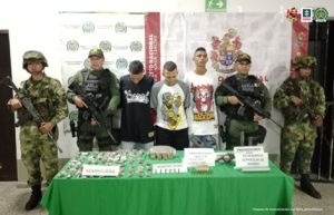 En la imagen se observa a los tres capturados junto a uniformados del Gaula de la Policía y Ejército Nacional. En la parte posterior los banners que identifican a la Policía y Ejército Nacional.