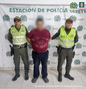 En la imagen se ve una persona detenida entre dos uniformados de la Policía.