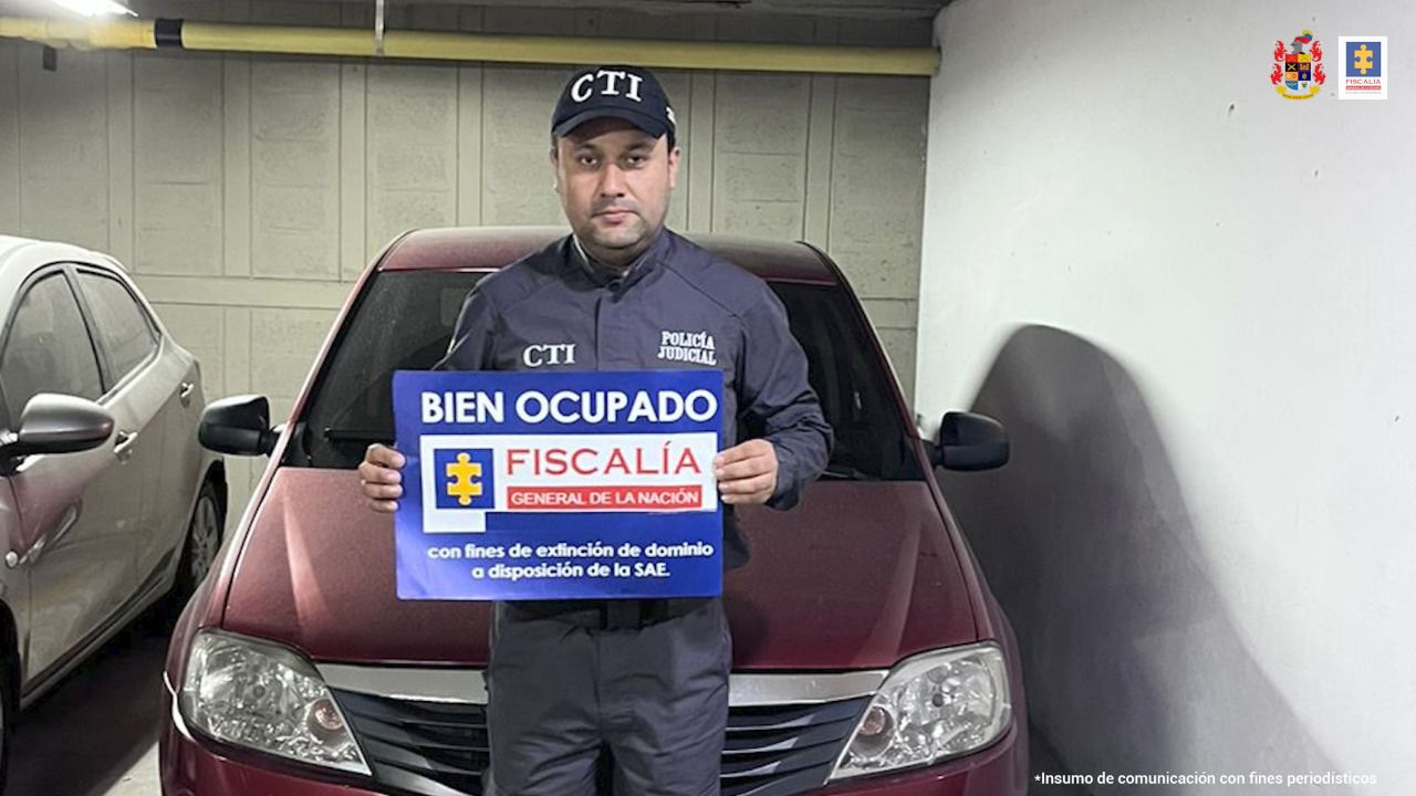 Puede verse una persona del CTI sosteniendo un cartel y atrás se ve un vehículo afectado con medidas cautelares.