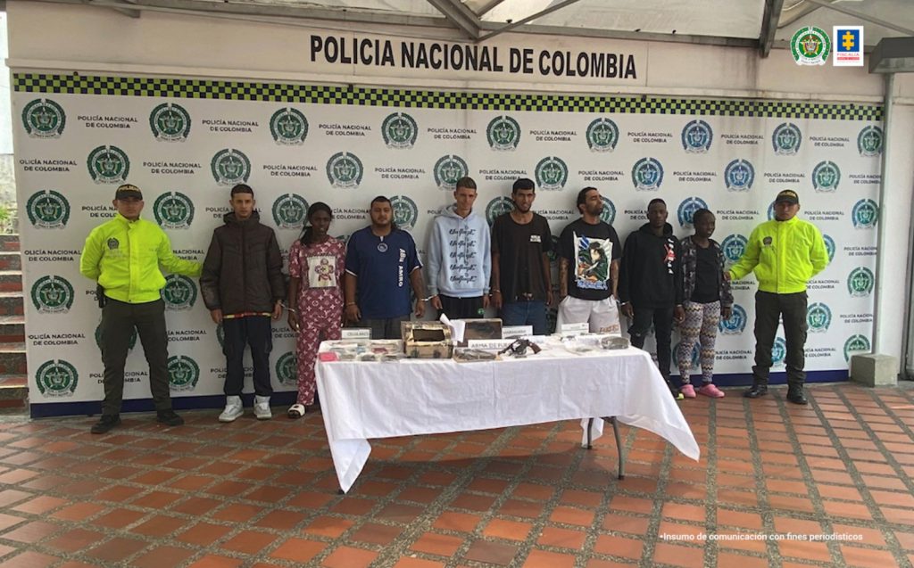 se observan los detenidos de frente en fila y a cada costado funcionarios de la Policía Nacional. Atrás un pendón de Policía Nacional