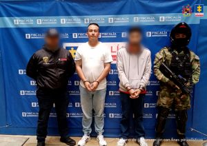 En la imagen está el oficial vestido de civil con un servidor del  Cuerpo Técnico de Investigación y otro Ejército nacional, ubicados adelante de un pendón azul de la Fiscalía General de la Nación. 