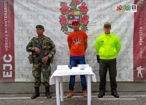 En la imagen el procesado con un servidor del Ejército y uno de la Policía Nacional.