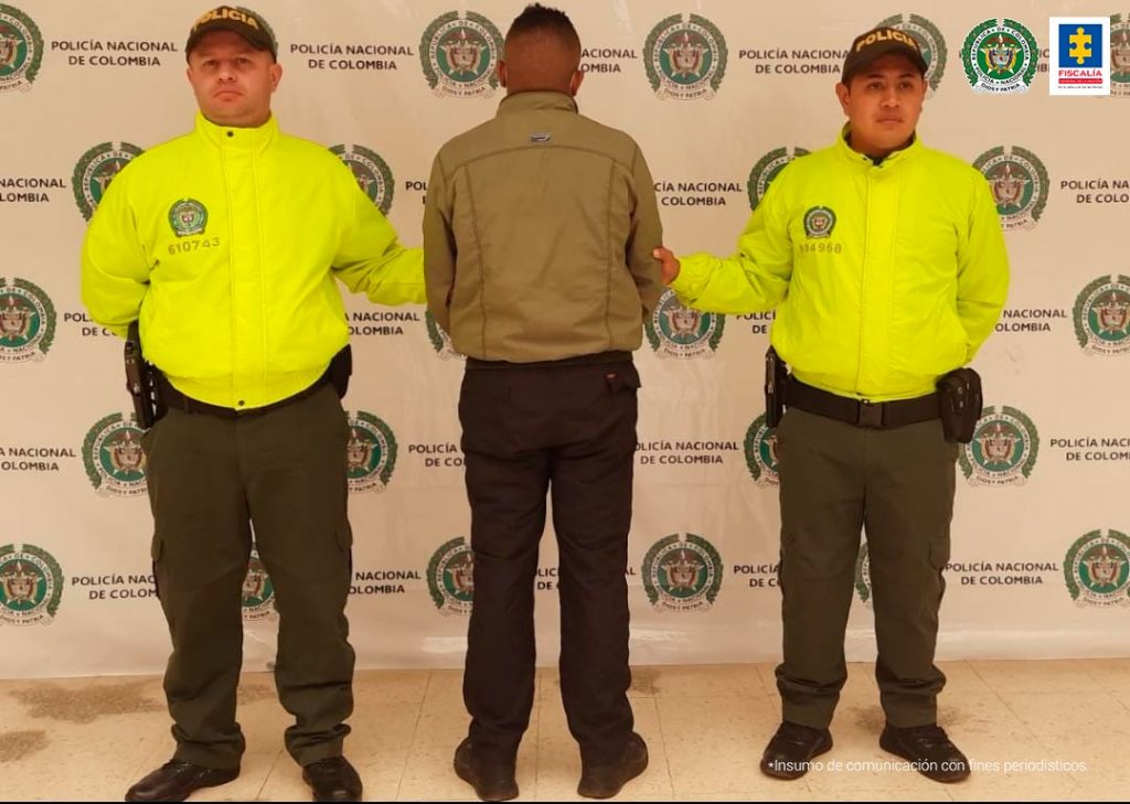 En la fotografía aparece el capturado junto a dos agentes de la Policía Nacional. En la parte superior está un banner de la Policía Nacional