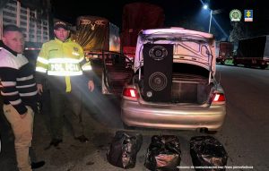 En la imagen se observa la marihuana incautada,el baul del carro y uniformados de la Policía Nacional