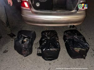 En la imagen se observa la marihuana incautada,el baul del carro y uniformados de la Policía Nacional