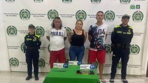 En la foto aparecen los capturados con el backing de la policía de fondo y dos uniformados al lado y lado.