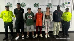 en la imagen se observan los procesados esposados y de pie, acompañados de uniformados de la Policía Nacional