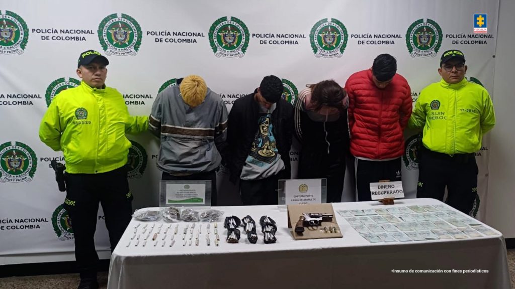 En la fotografía se observa a seis personas cuatro de ellas los capturados y dos uniformados de la policía nacional.
