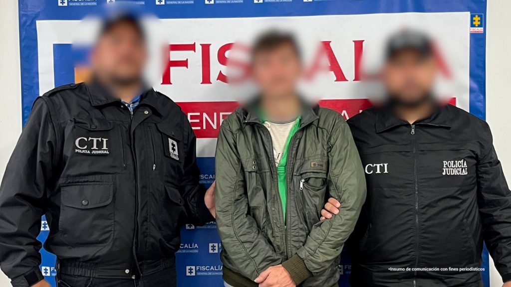 En la fotografía se observa a tres personas de ellas, dos funcionarios del CTI y el capturado.