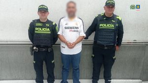 En la fotografía se encuentran tres personas dos de ellas uniformados de la Policía Nacional y el procesado. 