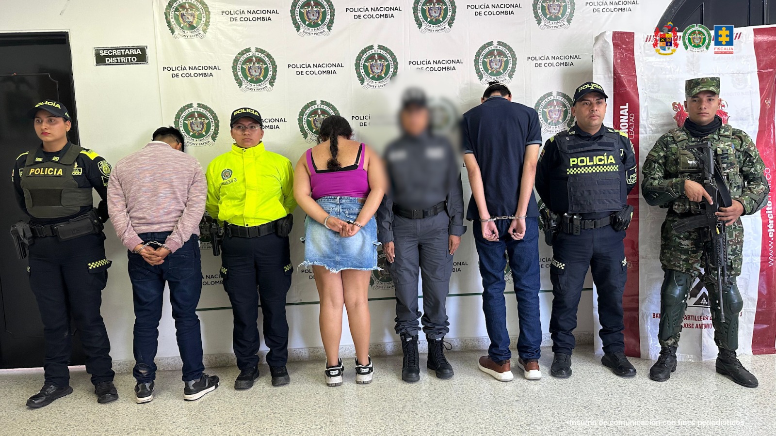 En la imagen se ven capturados de espalda junto a uniformados de la Policía. 