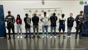 En la imagen está la mujer y los 6 hombres con 2 uniformados del Gaula de la Policía a los lados