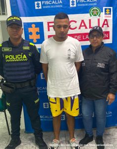 En la fotografía se aprecia de pie y con los brazos atrás a Pablo Esteban Sánchez Arango. Viste Camisa de manga corta blanca, bermuda de color amarillo con estampados negros y zapatillas blancas con negro. Al lado izquierdo hay una servidora del CTI de la Fiscalía y al lado derecho hay un uniformado de la Policía Nacional. Detrás de ellos hay un pendón institucional de la Fiscalía.