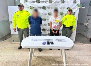 En la imagen aparecen los procesados con el rostro difuminado, esposados y de pie, en compañía de dos uniformados de la Policía Nacional