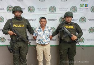 En la fotografía se ve a un hombre capturado en medio de dos uniformados de la Policía. 