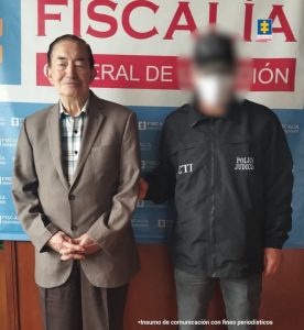 En la fotografía aparece el capturado junto a un servidor del CTI. En la parte superior está un banner de la Fiscalía General de la Nación