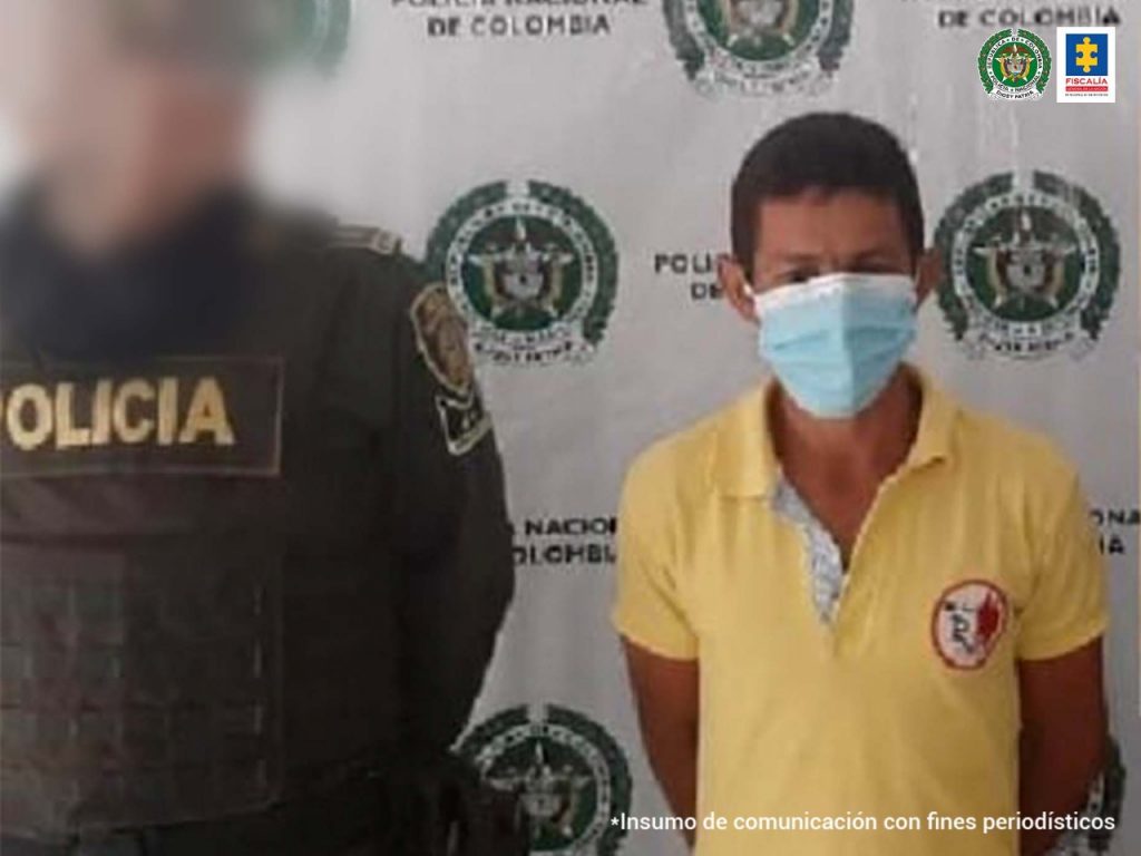 En la imagen se observa una persona detenida junto con un patrullero de la Policía