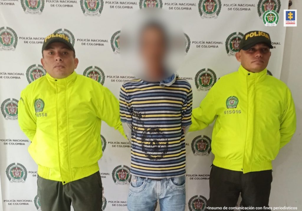 En la imagen se ve una persona capturada entre dos uniformados de la Policía.