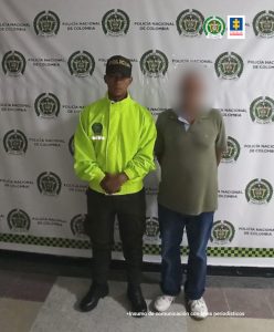 En la imagen aparece el investigado con el rostro distorsionado y al lado de un patrullero de la Policía Nacional