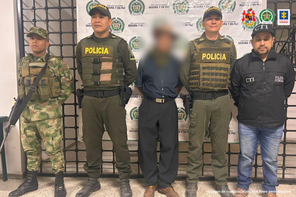 En la fotografía aparece un hombre capturado, acompañado de un servidor del Cuerpo Técnico de Investigaciones (CTI), dos uniformados de La Policía Nacional y uno del Ejército Nacional. En la parte posterior un banner con logos de la entidad.