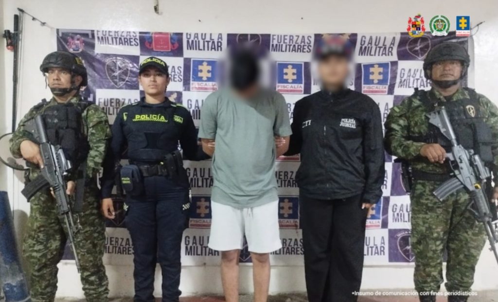 En la fotografía aparece un hombre capturado, un servidor del CTI, acompañado de dos uniformados de la Policía y del Ejército Nacional. En la parte posterior un banner con logos de la entidad.