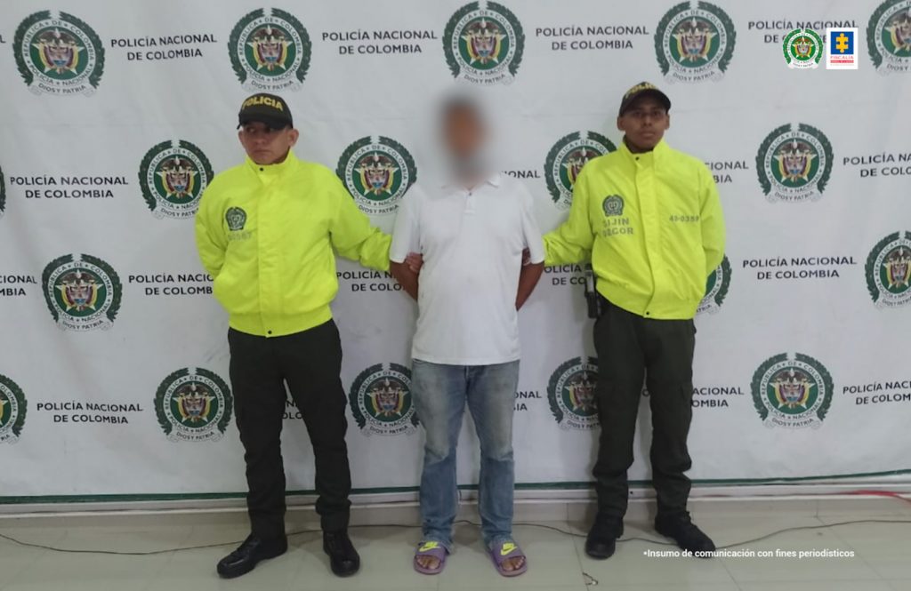 En la imagen se ve una persona detenida entre dos uniformados de la Policía.