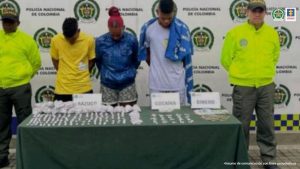 En la foto se aprecia de pie y con los brazos atrás a Daniels Mauricio Escobar Quiñónez, Juana Bonilla Sinisterra y Jeison David Arango Perdigón. Delante de ellos hay una mesa con mantel verde y sobre ella hay gran cantidad de bolsas plásticas con contenido blanco y dinero en efectivo. Asimismo, hay tres letreros que dicen: ‘Bazuco’, ‘Cocaían’ y ‘Dinero’. Detrás de ellos hay un pendón institucional de la Policía Nacional.
