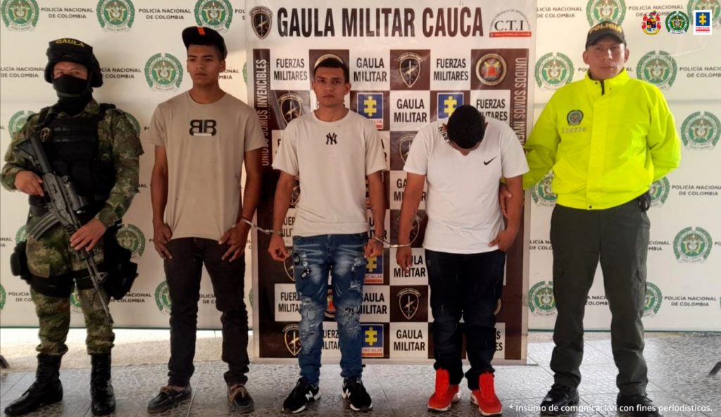 En la foto aparecen los tres presuntos implicados en el hurto violento de motocicletas. A lado y lado de ellos hay uniformados de la Policía y Ejército Nacional. Detrás de ellos hay un pendón interinstitucional con logos del Gaula Ejército, Policía Nacional y Fiscalía.