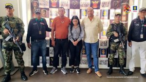En la fotografía aparecen tres personas capturadas, acompañados de un uniformado de la Policía, el Ejército Nacional y dos servidores del (CTI). En la parte posterior un banner con logos de la entidad.