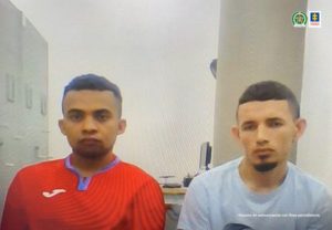 En la imagen se ven dos personas, de suéter rojo y blanco, en medio de una audiencia.