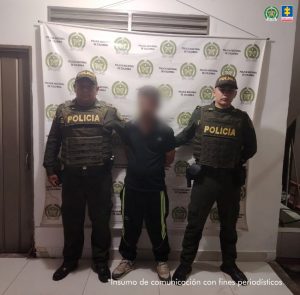 En la fotografía se ve a un hombre con la cara difuminada, junto a dos uniformados de la Policía Nacional, quien presuntamente habría atacado con arma blanca a una mujer en Pijao (Quindío).